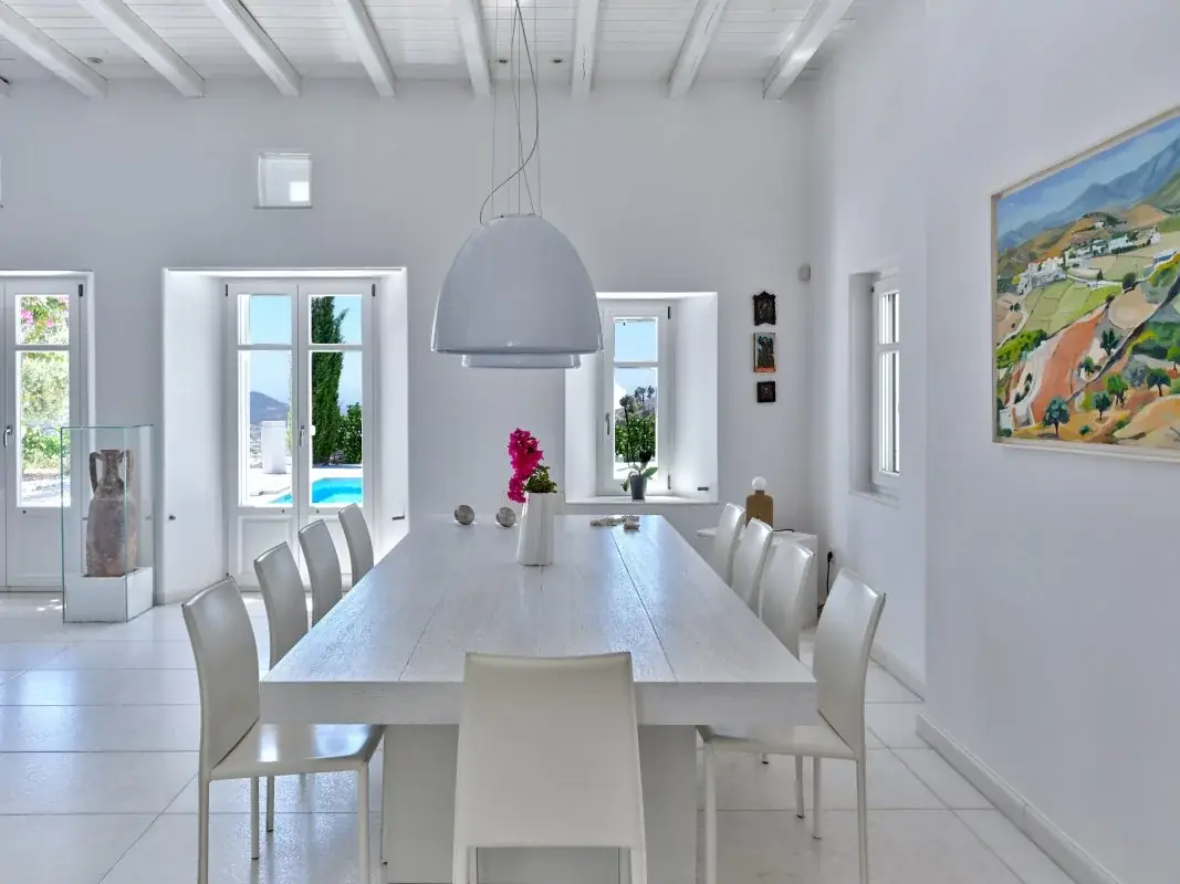 Minimal white dining room looking toward the pool