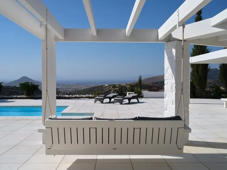 Shaded poolside day bed with panoramic Aegean view