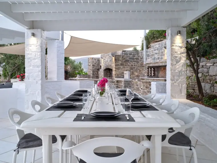 Outdoor dining terrace beside the stone barbecue and wood oven