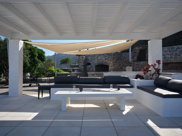 Shaded outdoor lounge beside the stone kitchen