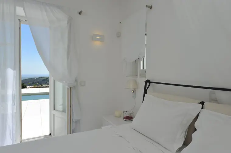 Pool-facing double bedroom with sheer curtains