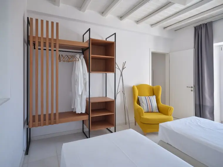 Twin bedroom with custom wood wardrobe and yellow chair