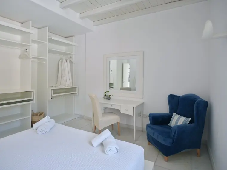Double bedroom with dressing area and blue reading chair