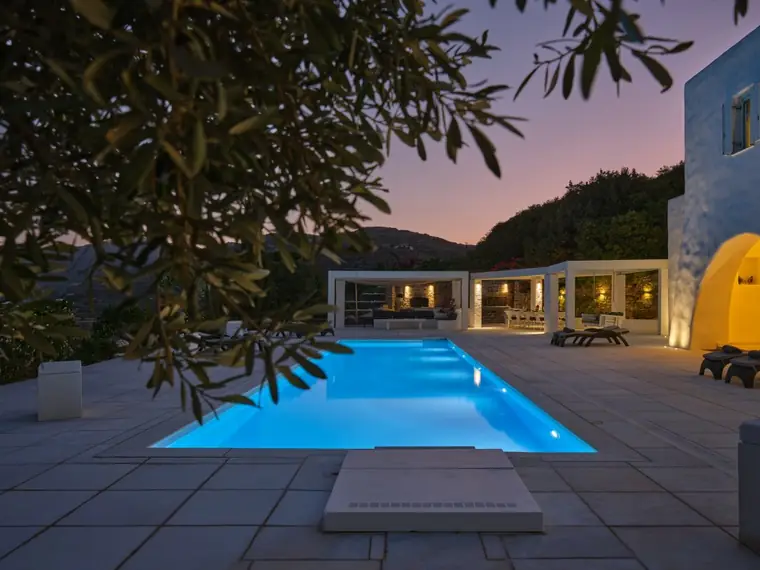 Illuminated 17-metre pool and terrace at twilight